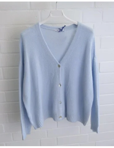 Hellblaue Damen Strickjacke mit Knöpfen und V-Ausschnitt vor weißer Wand