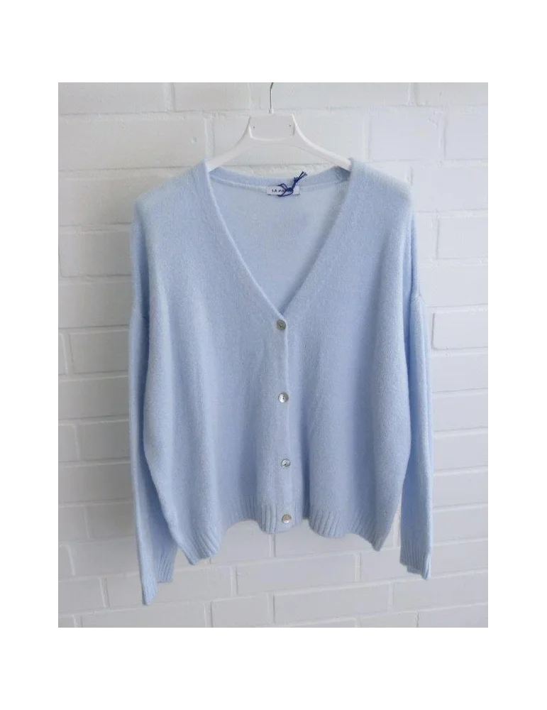 Hellblaue Damen Strickjacke mit Knöpfen und V-Ausschnitt vor weißer Wand