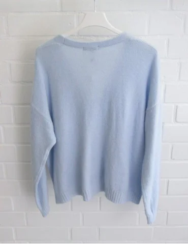 Rückansicht Hellblaue Damen Strickjacke mit Knöpfen und V-Ausschnitt vor weißer Wand