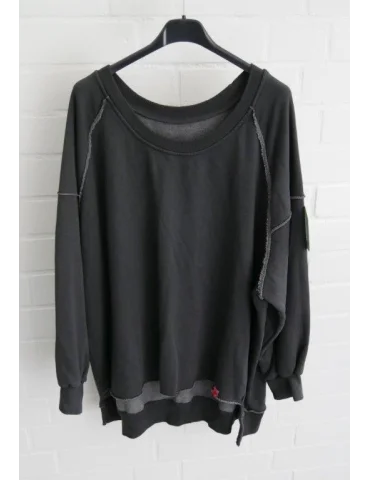 Anthrazitarbenes Sweatshirt im Vokuhila Style vor weißer Wand