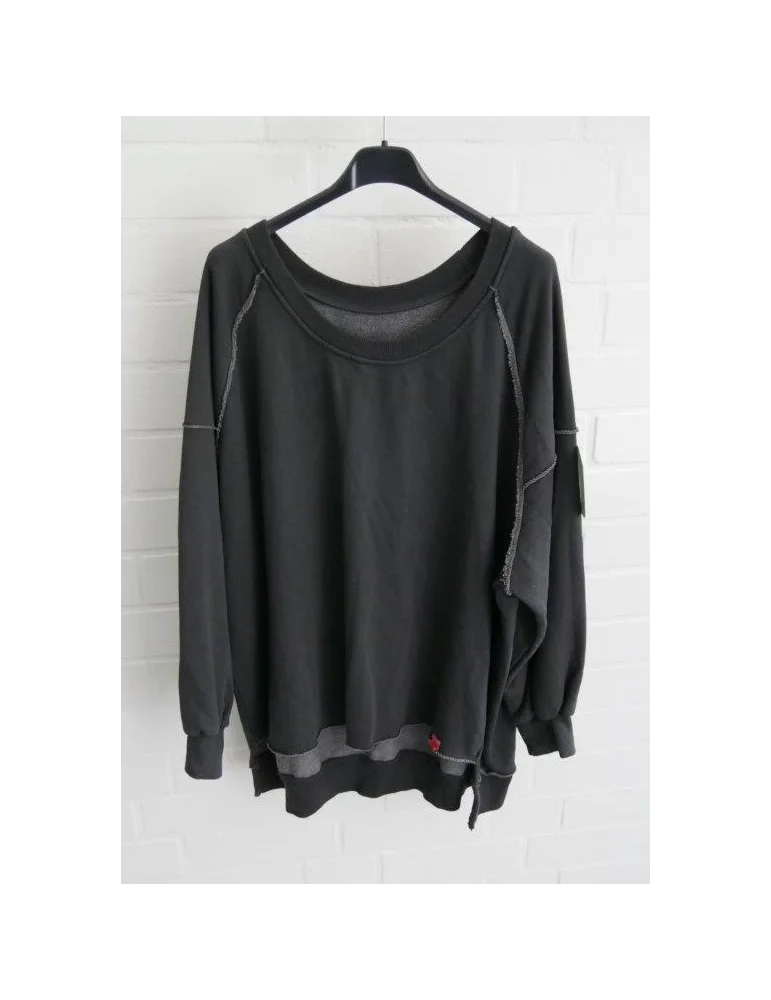 Anthrazitarbenes Sweatshirt im Vokuhila Style vor weißer Wand