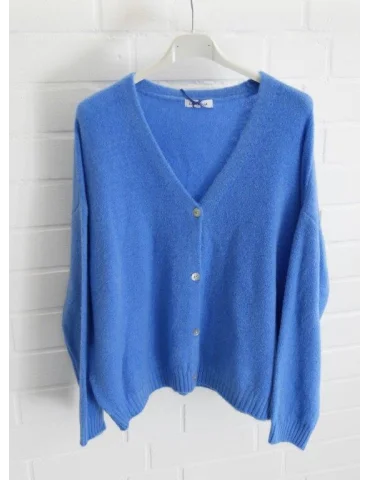 Royalblaue Damen Strickjacke mit Knöpfen und V-Ausschnitt vor weißer Wand