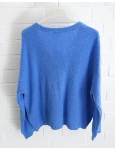 Royalblaue Damen Strickjacke mit Knöpfen und V-Ausschnitt vor weißer Wand von hinten