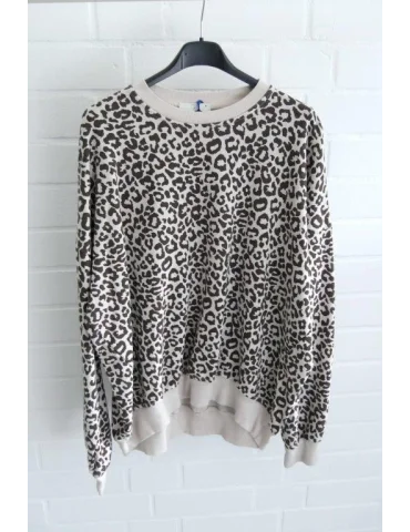 Beiges langarm Sweatshirt mit braunem Leomuster vor weißer Wand
