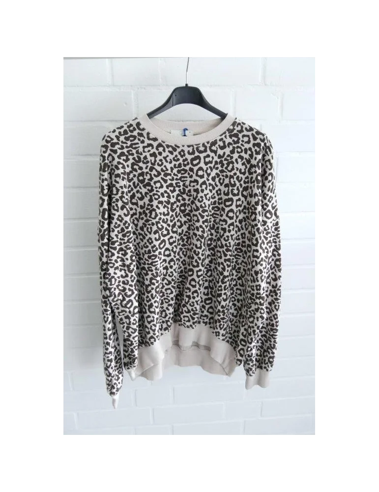 Beiges langarm Sweatshirt mit braunem Leomuster vor weißer Wand