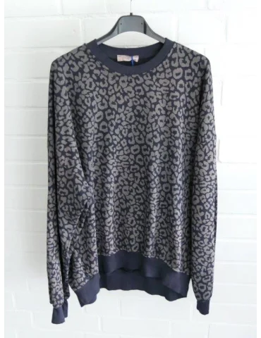 Dunkelblaues langarm Sweatshirt mit grauem Leomuster vor weißer Wand