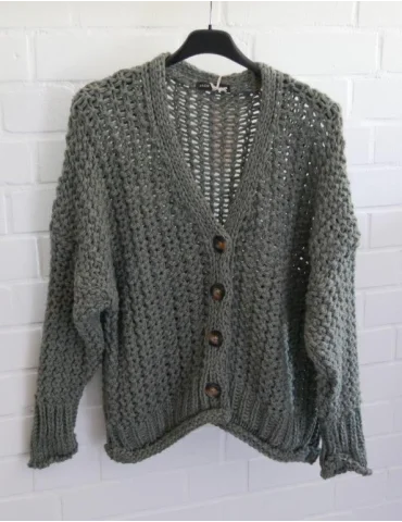 Damen Grobstrickjacke mit Knöpfen vor weißer Wand