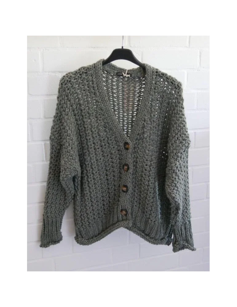 Damen Grobstrickjacke mit Knöpfen vor weißer Wand