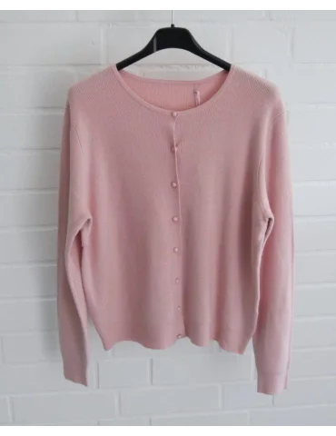 Rose Ripp Strickjacke vor weißer Wand