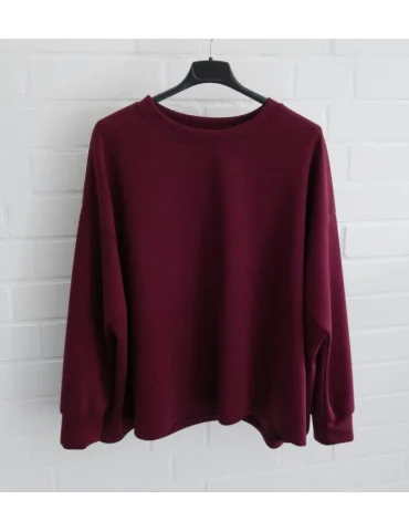 Kastig geschnittener weinroter Damen-Pullover mit Rundhalsausschnitt an einem Bügel