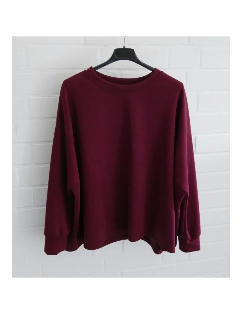 Kastig geschnittener weinroter Damen-Pullover mit Rundhalsausschnitt an einem Bügel