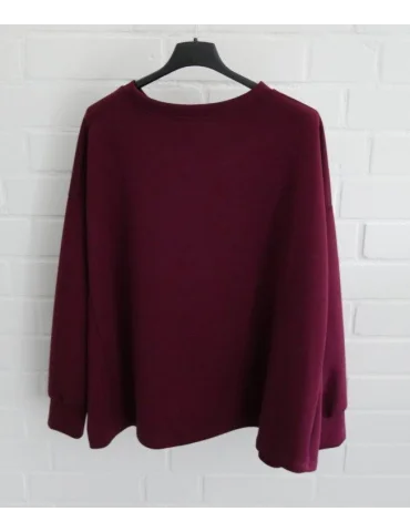Kastig geschnittener weinroter Damen-Pullover mit Rundhalsausschnitt an einem Bügel von hinten