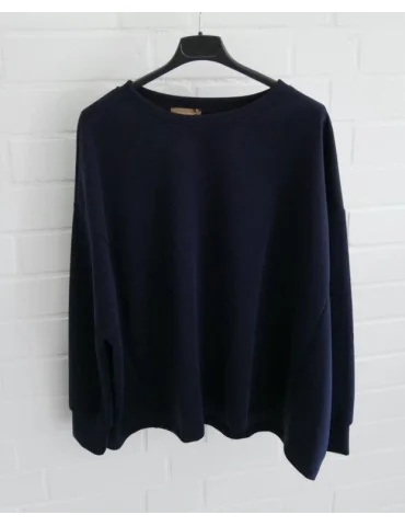 Kastig geschnittener dunkellauer Damen-Pullover mit Rundhalsausschnitt an einem Bügel