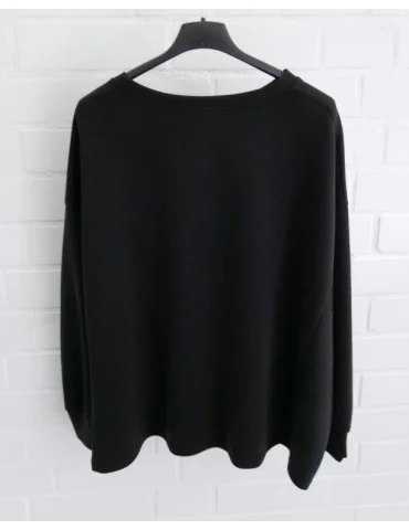 Kastig geschnittener schwarzer Damen-Pullover mit Rundhalsausschnitt an einem Bügel von hinten