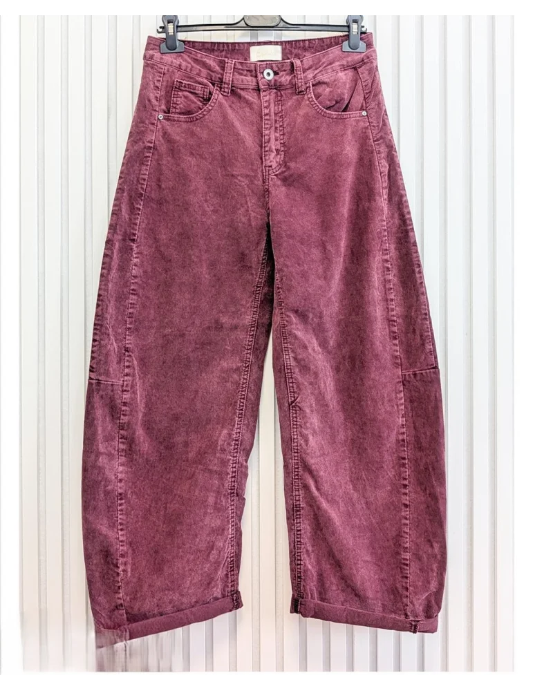 Beerefarbene Cordhose für Damen in verwaschener Optik mit weitem Bein vor weißer Wand