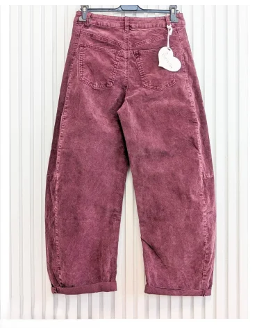 Beerefarbene Cordhose für Damen in verwaschener Optik mit weitem Bein vor weißer Wand von hinten