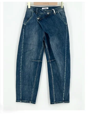 Mittelblaue Barrel-Leg Jeans für Damen mit asymmetrisch schrägem Bund an einem Kleiderbügel