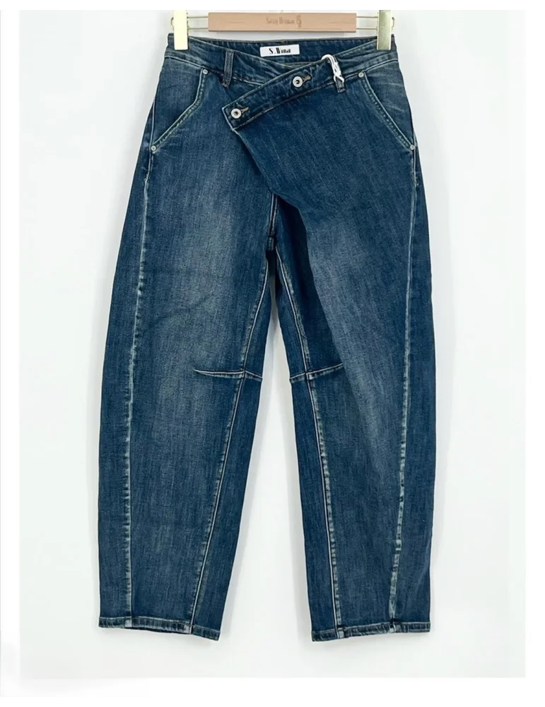 Mittelblaue Barrel-Leg Jeans für Damen mit asymmetrisch schrägem Bund an einem Kleiderbügel