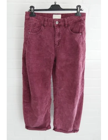 Beerefarbene Cordhose für Damen in verwaschener Optik mit weitem Bein vor weißer Wand