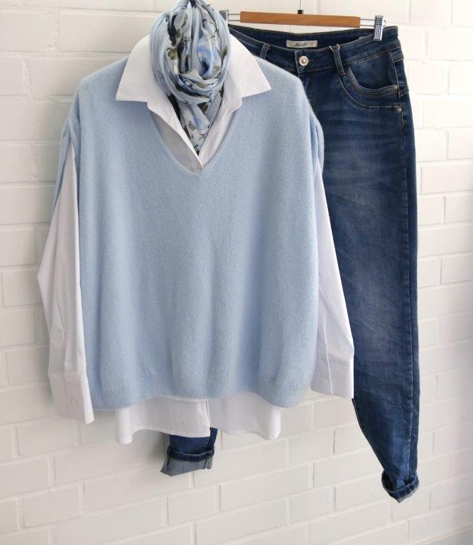 Dunkle Jeans, weiße Bluse, hellblauer Pullunder mit passendem Schal dekoriert