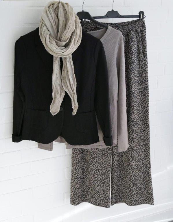 Leo Print Marlene Jogger mit schlammfarbenem Longsleeve, schwarzem Blazer und beigem Schal hängend vor weißer Wand