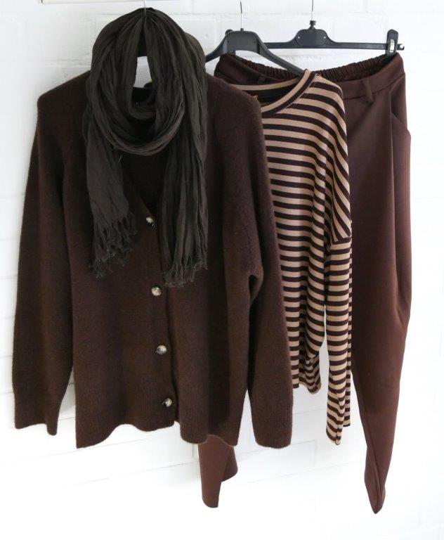 Braune Scuba Hose, braun gestreiftes Longsleeve, braune Strickjacke und brauner Baumwoll Schal hängend vor weißer Wand