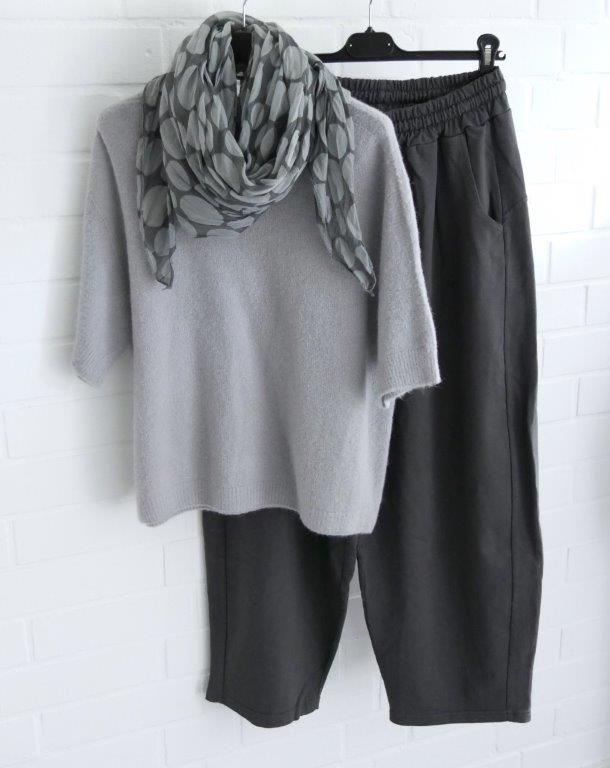 Anthrazitfarbene Jogger mit hellgrauem kurzarm Pullover und gepunktetem Schal